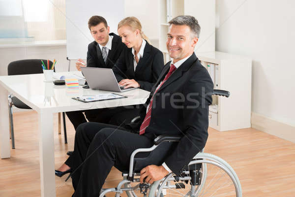 Empresário cadeira de rodas colegas escritório feliz maduro Foto stock © AndreyPopov