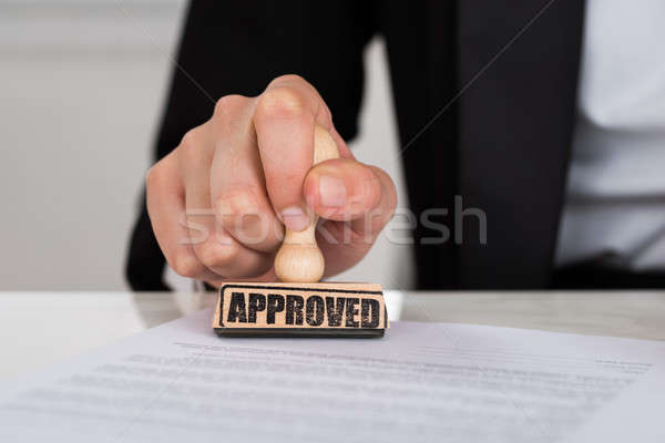 Businesswoman Stamping Approved On Contract Paper At Desk Stock photo © AndreyPopov