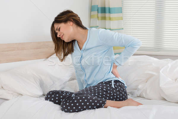 Frau Leiden Rückenschmerzen Sitzung Bett Büro Stock foto © AndreyPopov