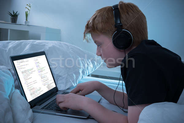 Fiú programozás laptop zenét hallgat ház billentyűzet Stock fotó © AndreyPopov