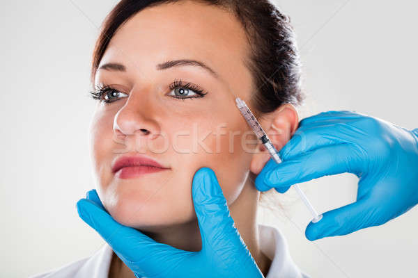 Person's Hand Injecting Syringe On Woman's Face Stock photo © AndreyPopov