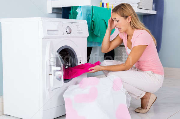 Woman Looking At Stained Cloth In Washing Machine Stock photo © AndreyPopov