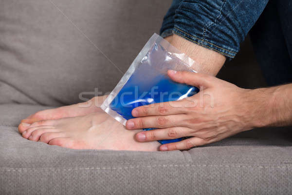 Person's Hand Holding Ice Gel Pack On Ankle Stock photo © AndreyPopov