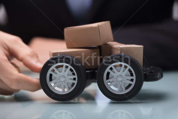 Hand Holding Black Cart With Stack Of Miniature Cardboard Boxes Stock photo © AndreyPopov