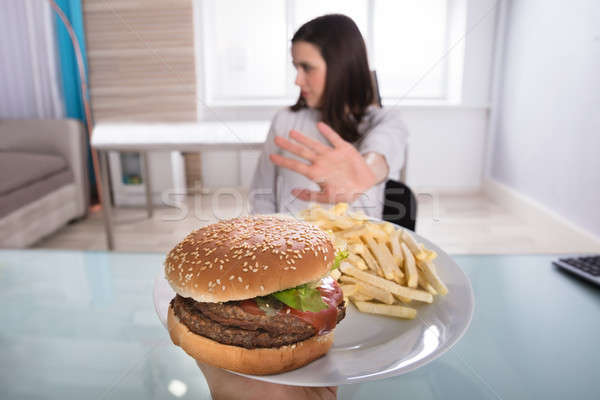 Mulher alimentos não saudáveis mulher jovem burger prato Foto stock © AndreyPopov