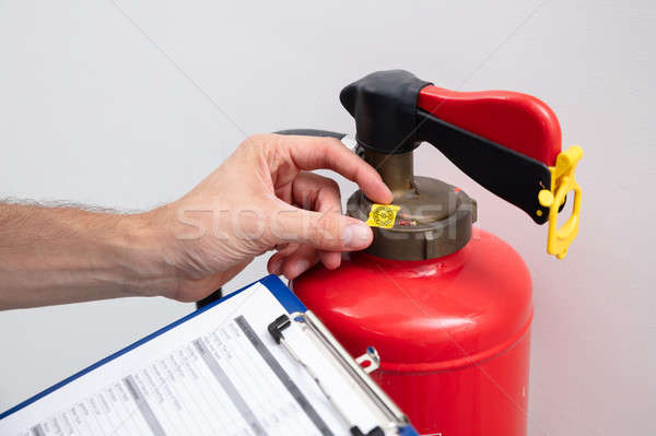 Man Checking Symbol On Fire Extinguisher Stock photo © AndreyPopov