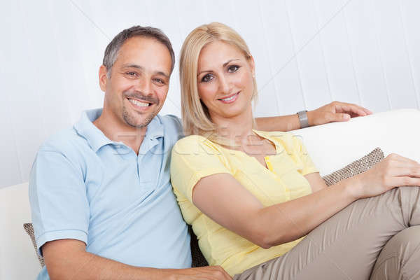 Loving couple relaxing on a sofa Stock photo © AndreyPopov