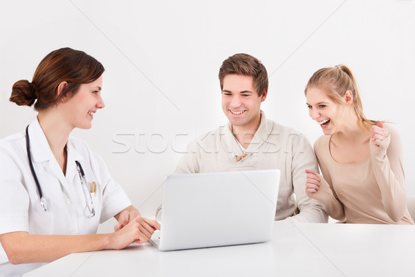 [[stock_photo]]: Couple · regarder · portable · médecin · excité · séance