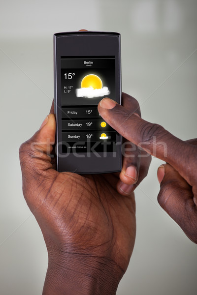 Persona guardando Meteo previsione primo piano telefono cellulare Foto d'archivio © AndreyPopov