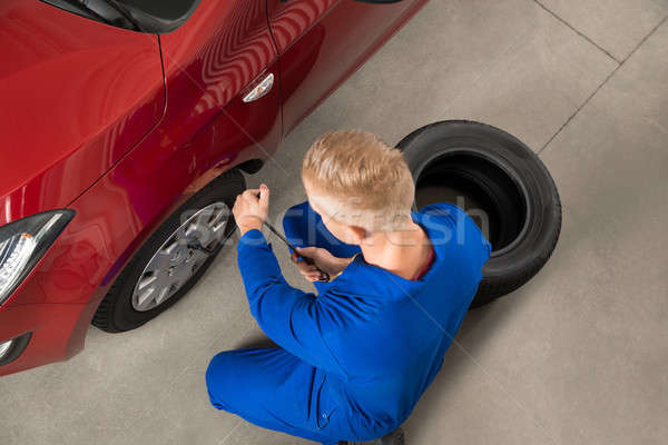Mechanic Fixing Car Tire With Wrench Stock photo © AndreyPopov
