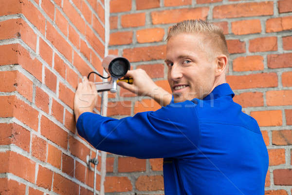 Smiling Technician Installing Camera On Wall Stock photo © AndreyPopov