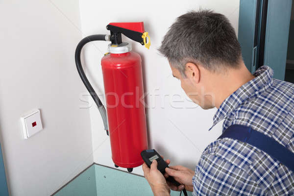 Man Inspecting Fire Extinguish Stock photo © AndreyPopov