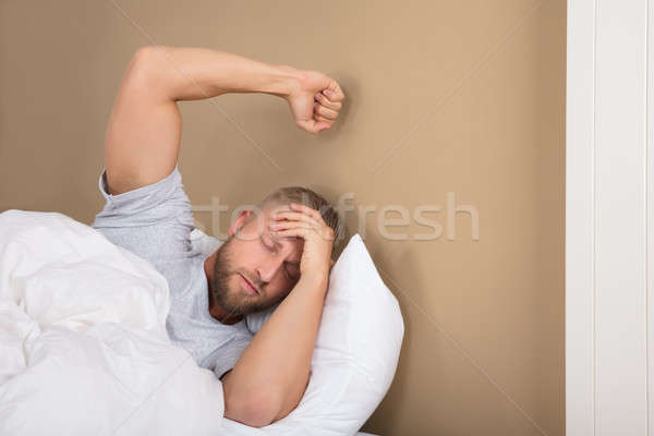 Unhappy Man Lying On Bed Stock photo © AndreyPopov