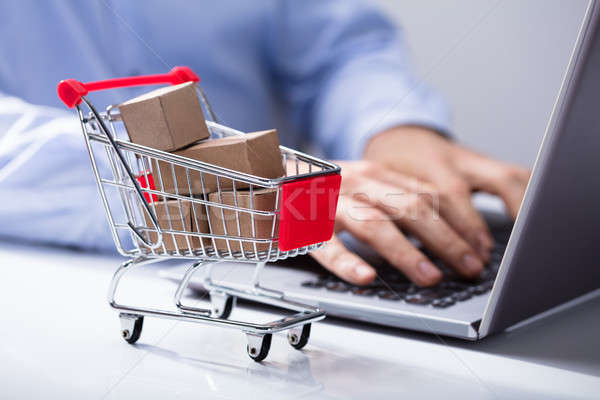 Foto stock: Homem · usando · laptop · carrinho · de · compras · secretária · miniatura · cartão