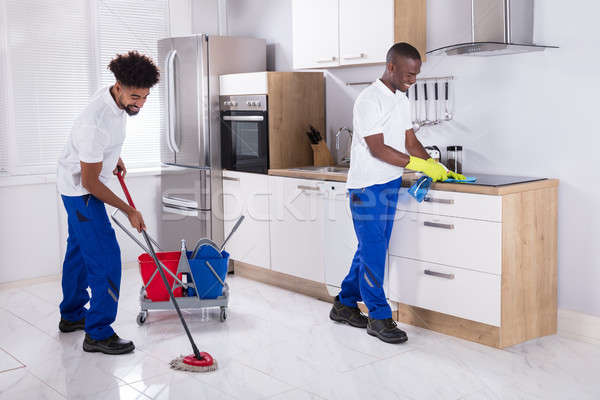 Smiling Two Young Male Janitor Cleaning The Kitchen Stock photo © AndreyPopov