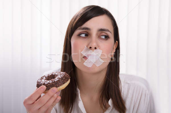 Woman With Sticky Tape Over Her Mouth Holding Donut Stock photo © AndreyPopov
