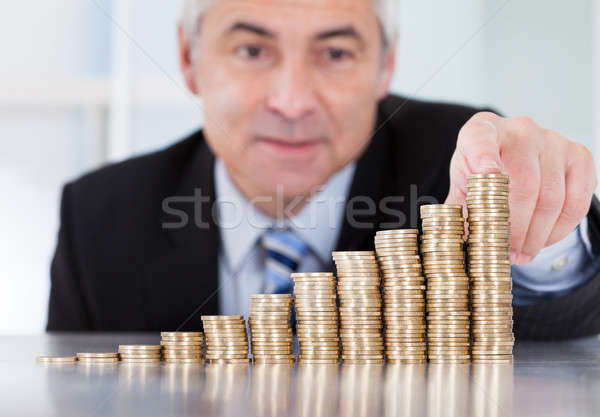 Stock photo: Mature Businessman With Stack Of Coins