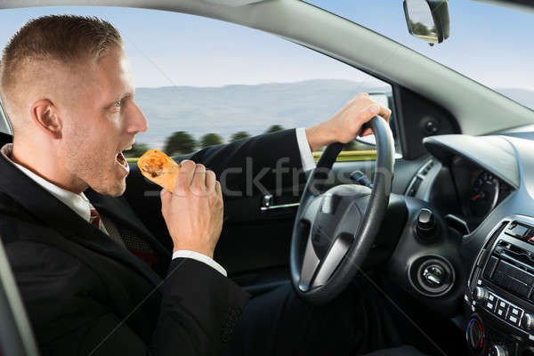 Businessman Eating Snack While Driving Stock photo © AndreyPopov