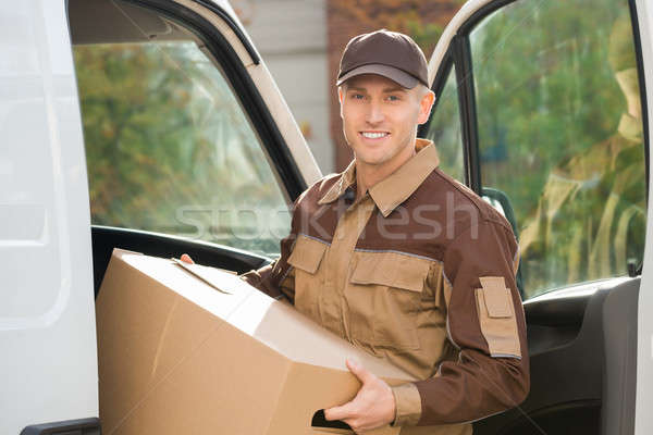 Young Delivery Man Removing Cardboard Box From Truck Stock photo © AndreyPopov