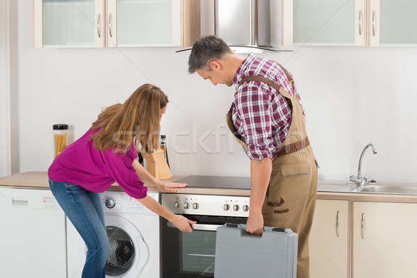 Woman Showing Oven To Worker Stock photo © AndreyPopov