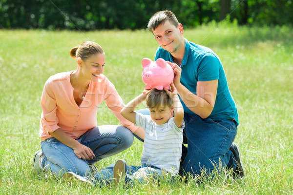 Parents With Their Son Holding Piggy Bank Stock photo © AndreyPopov