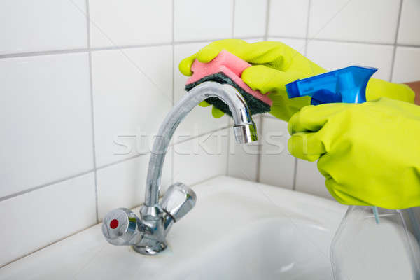 Woman Cleaning The Basin Tap With Sponge Stock photo © AndreyPopov