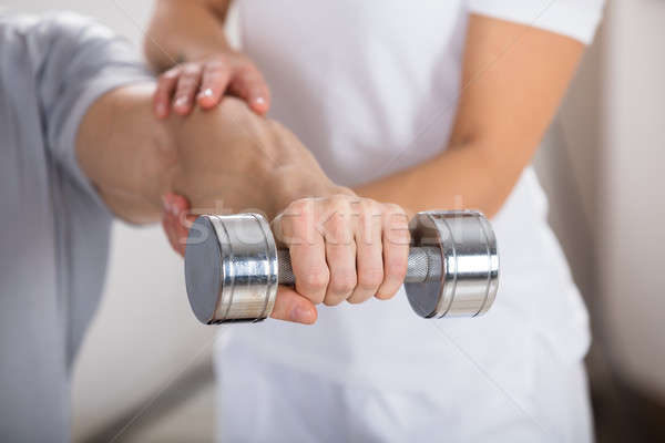 Physiotherapist Helping Man To Exercise Stock photo © AndreyPopov