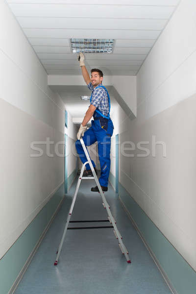 Electrician On Stepladder Installs Lighting To The Ceiling Stock photo © AndreyPopov