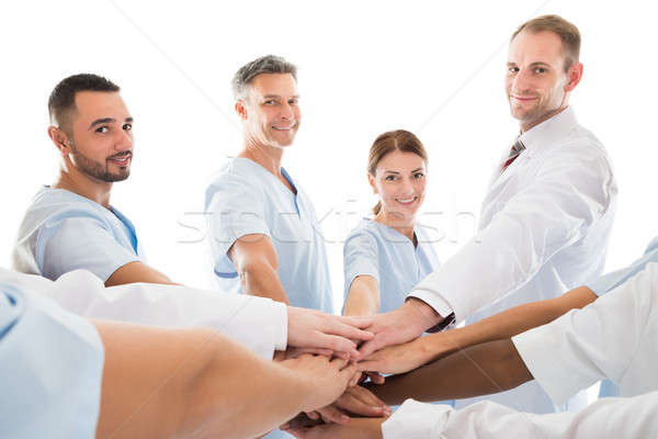 Portrait Of Smiling Medical Team Piling Hands Stock photo © AndreyPopov