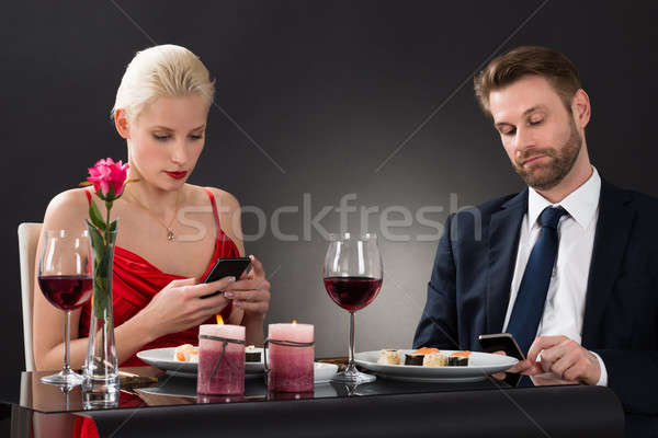 Couple Looking At Their Smartphone Stock photo © AndreyPopov
