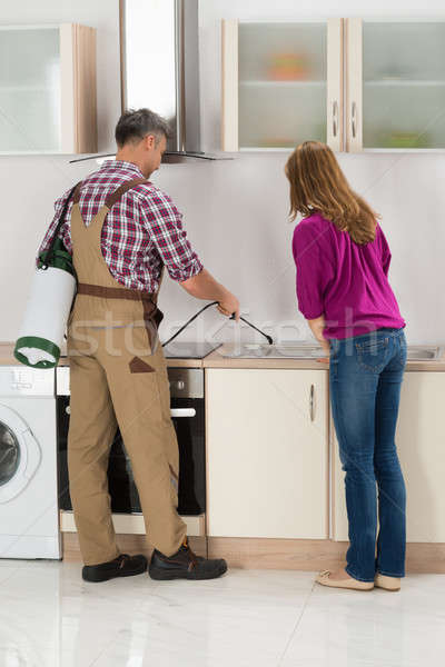 Stock photo: Worker Spraying Insecticide In Kitchen