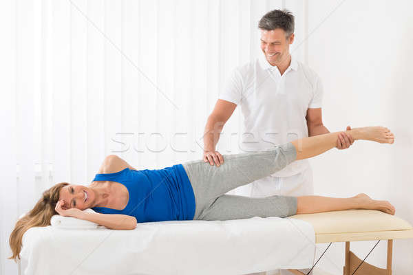 Male Therapist Giving Leg Massage To Woman Stock photo © AndreyPopov