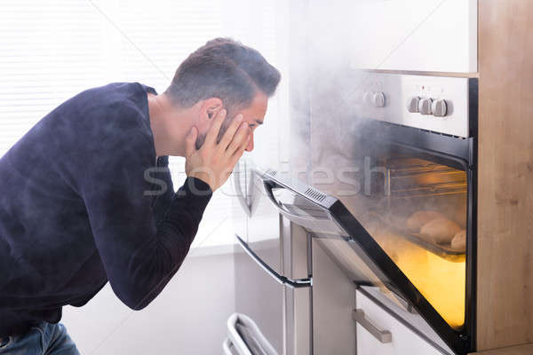 Shocked Man Looking At Burnt Cookies In Oven Stock photo © AndreyPopov