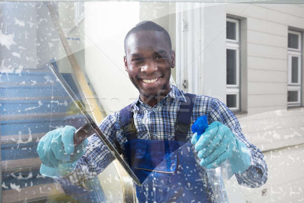 Male Worker Cleaning Glass With Squeegee Stock photo © AndreyPopov