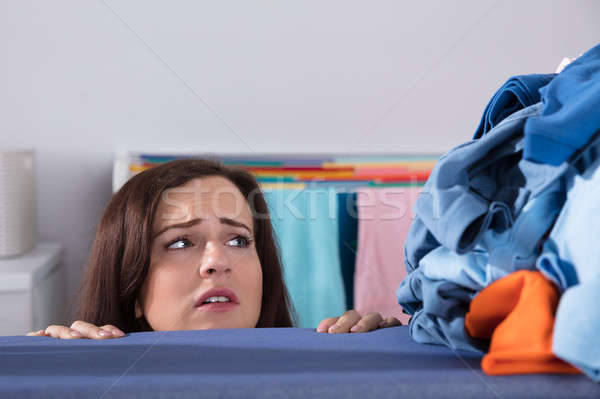 Sad Woman Looking At Pile Of Clothes Stock photo © AndreyPopov