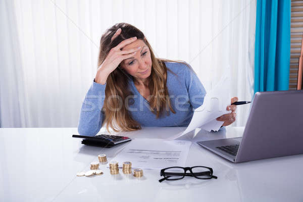 Stressed Businesswoman With Invoice At Workplace Stock photo © AndreyPopov