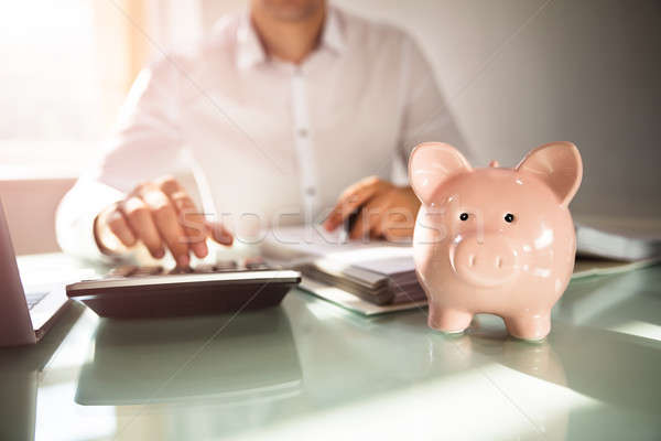 Close-up of a piggybank on reflective desk Stock photo © AndreyPopov