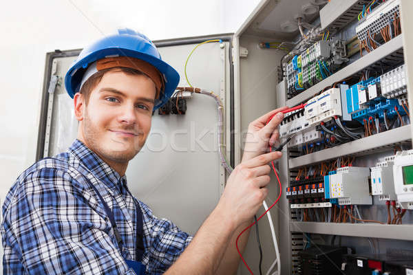 Stock photo: Technician Examining Fusebox With Multimeter Probe