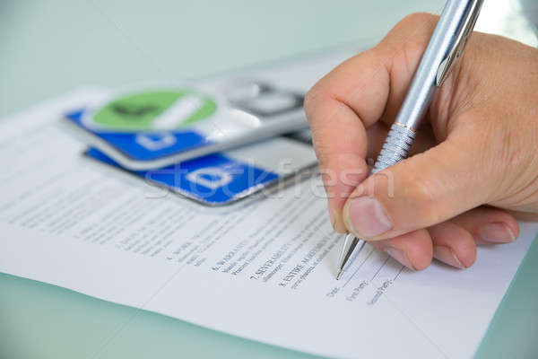 Close-up Of Hand Filling Car Sale Contract Form Stock photo © AndreyPopov