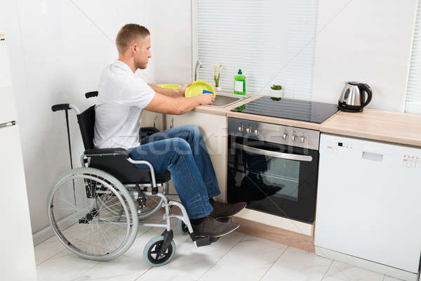 Man On Wheelchair Washing Dishes Stock photo © AndreyPopov