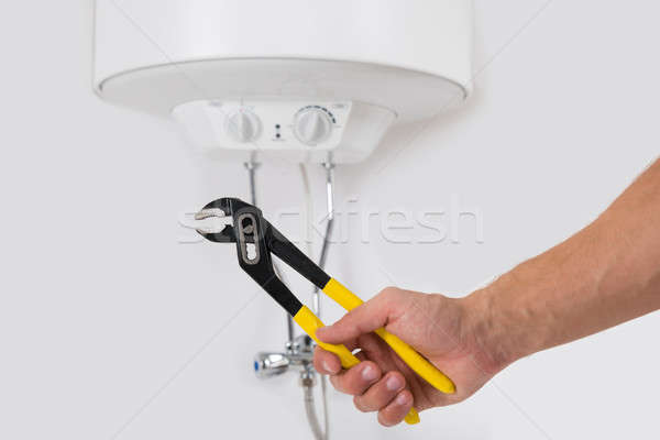 Person Hands With Wrench In Front Of Electric Boiler Stock photo © AndreyPopov