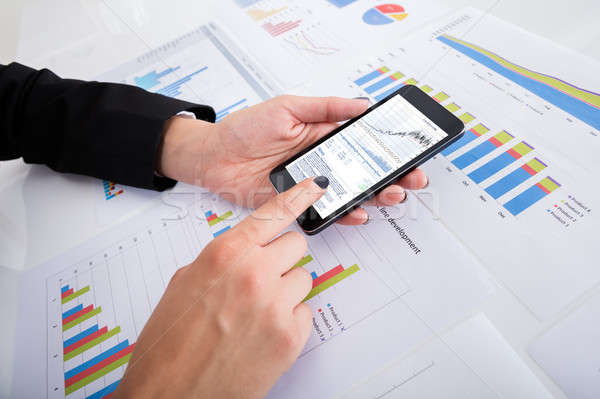 Businesswoman Analyzing Data Using Smartphone Stock photo © AndreyPopov