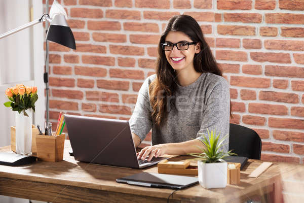 Foto stock: Sorrindo · usando · laptop · jovem · mesa · de · escritório · negócio · mulher