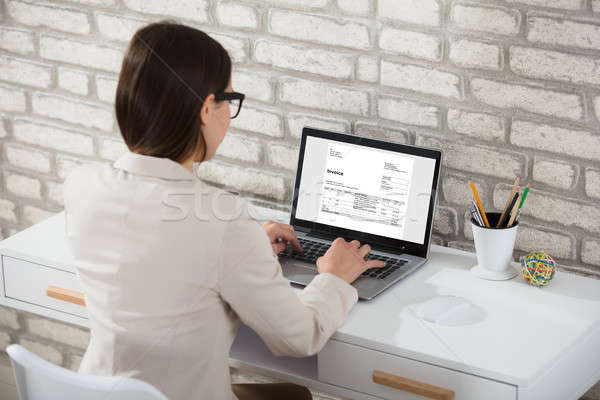 Mujer de negocios mirando factura documento portátil Foto stock © AndreyPopov