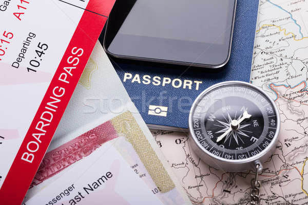 Smartphone, Boarding Pass Ticket, Passport And Compass On Map Stock photo © AndreyPopov
