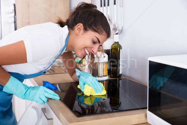 Femeie curăţenie aragaz fericit bucătărie Imagine de stoc © AndreyPopov