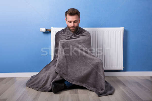 [[stock_photo]]: Homme · séance · chauffage · maison · jeune · homme · couverture