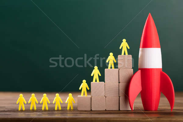 Rocket Besides Yellow Human Figures On Top Of Wooden Blocks Stock photo © AndreyPopov