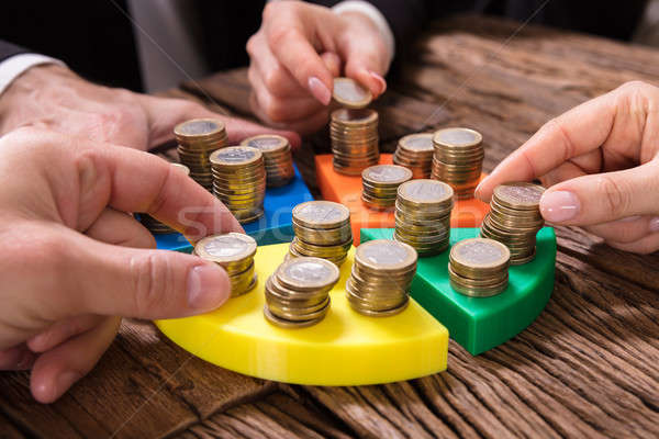Businesspeople Stacking Coins On Pie Chart Stock photo © AndreyPopov