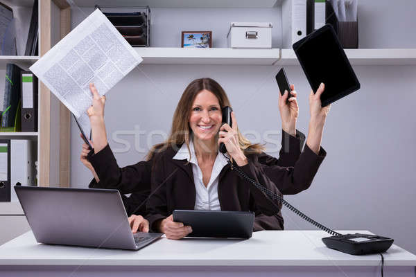 Femme d'affaires multitâche travaux bureau portrait heureux Photo stock © AndreyPopov